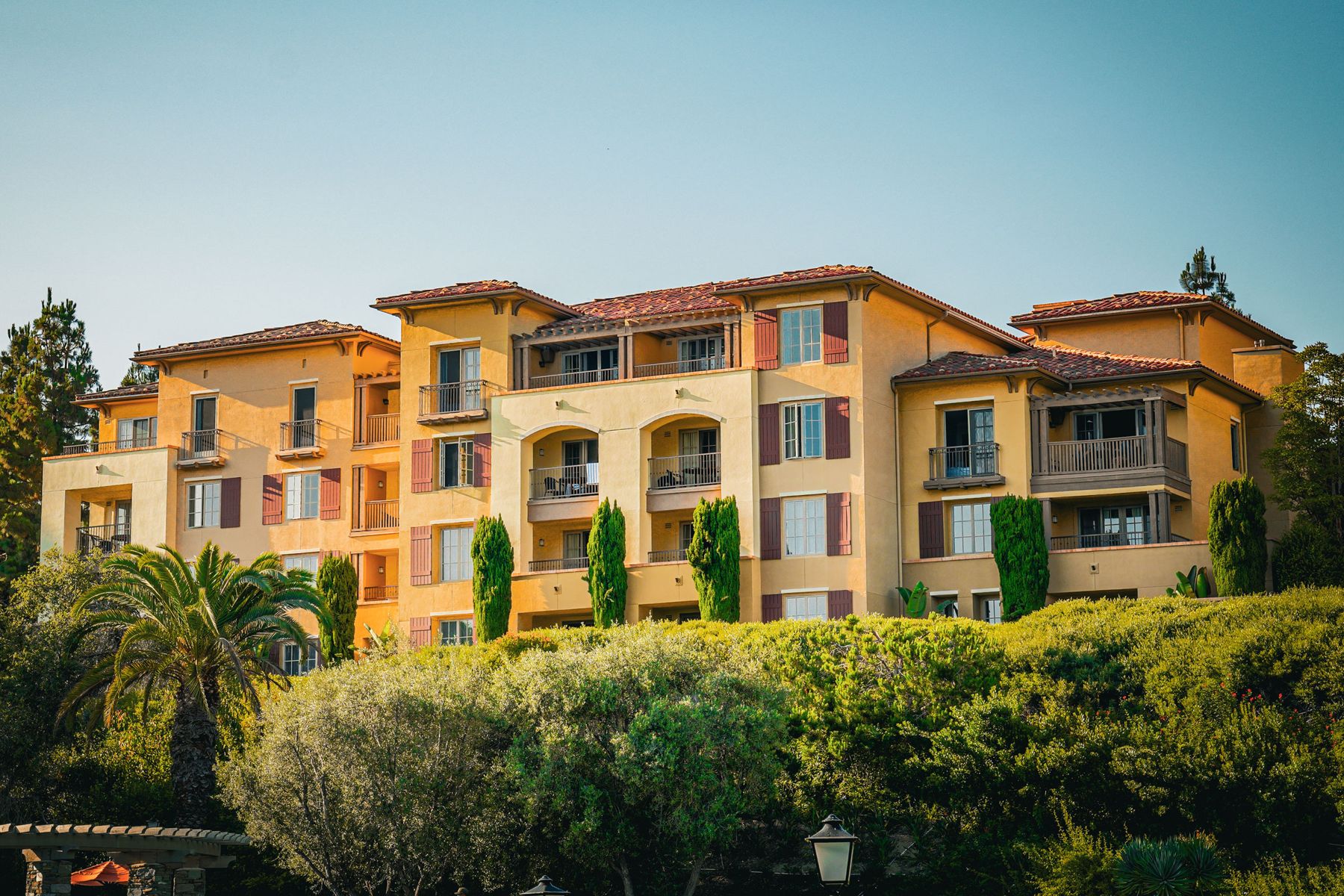 Hillside hotel with stucco walls and tile roofs at golden hour
