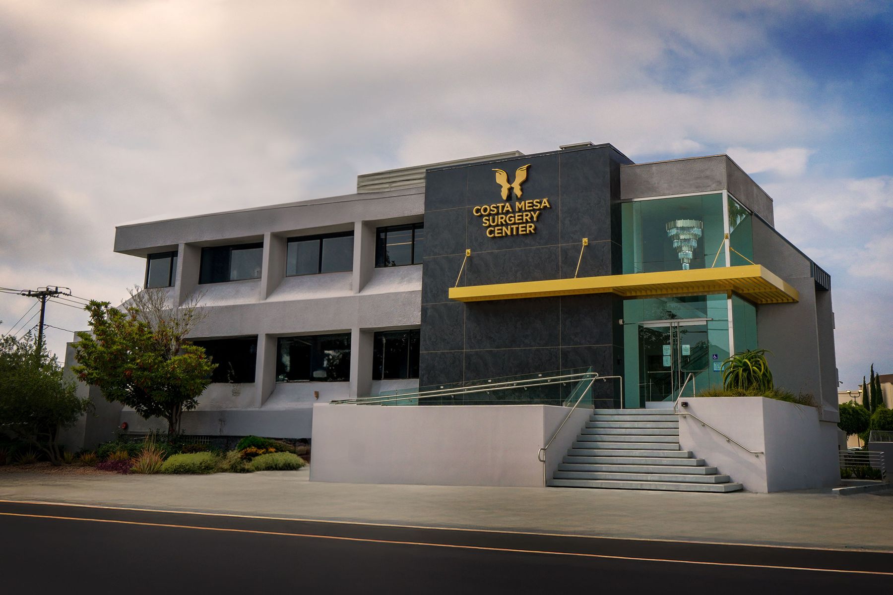Two-storey surgery center with a dark stone entry and glass lobby