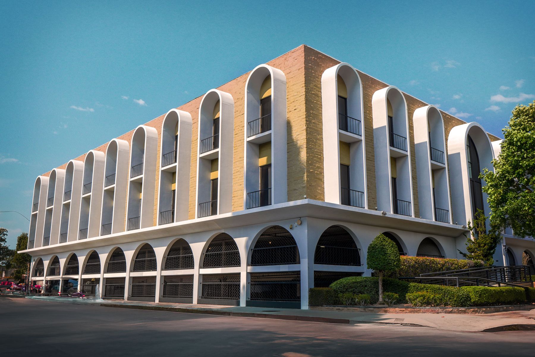 Three-storey office building with white arches and brick walls